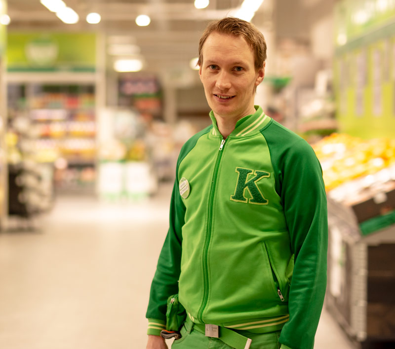 Butikksjef hos Kiwi med butikken i bakgrunnen